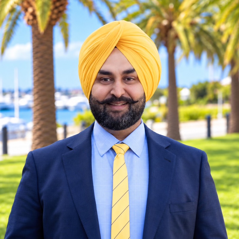 Varinder Sran, wearing a navy suit and yellow turban